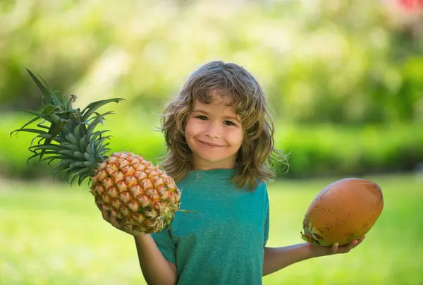 小男孩拿着菠萝和椰子 笑容满面 夏季水果 — 图库照片