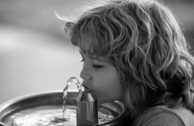 Dışarıdaki çeşmeden su içen çocuk portresini kapatın.