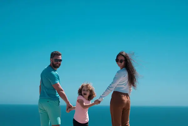 Weekend family concept. Happy family holidays. Joyful father, mother, baby son walk of sea sand beach. Active parents and people outdoor activity on summer vacations with children
