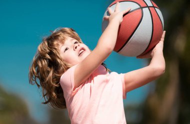 Parkta basketbol oynayan mutlu küçük çocuk. Çocuklar için spor