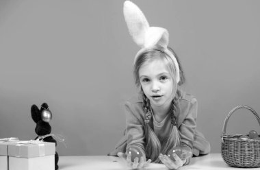 Paskalya günü tavşan kulaklı tatlı kız. Boyalı yumurta tutan kız.