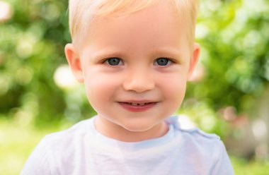 Yakından gülümseyen çocuk suratı. Arka planda gülümseyen çocuk portresi