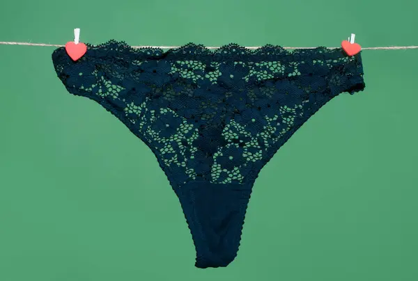 女人性感的黑色内裤挂在绳子上 与绿色背景隔离 蕾丝内衣 女人内裤 — 图库照片