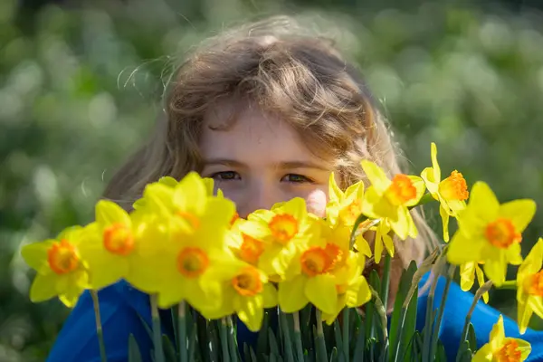 小孩子在户外闻到春天水仙花的香味 孩子们在春天的花园里玩耍 孩子们面对着盛开的樱桃树 春花期间的快乐孩子 — 图库照片