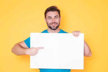 Bilgi konsepti. Boş pankartlı bir adam. Metnin ya da tasarımın için kopyalama alanı gösteriliyor. Stüdyo arka planında boş reklam panosu gösteren bir adam. Boş pano, reklam tabelası.