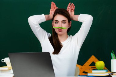 Çılgın öğrenci sınıf konseptinde eğleniyor. Öğrencinin ya da liseli kızın komik yüzü. Liseli kız çıldırıyor. Komik yüz ifadesi, duygu, tepki. Kolajlı komik kızın portresi.