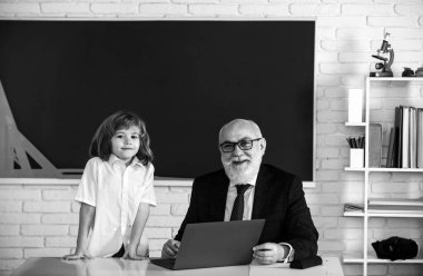 Okulda öğretmen ve öğrenci. Çocuklar konsept öğreniyor. Erkek ilkokulu. Yaşlı ve Genç