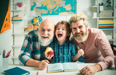 Büyükbaba, baba ve oğul, farklı yaşlarda okumaya hazır adamlar. Okulda mutlu bir aile. Üç erkek nesli. Bilgi ve eğitim kavramı
