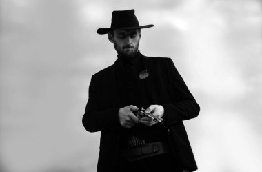 Amerikalı kovboy. Yakışıklı vahşi batılı adam. Vahşi batı silahları, klasik tabanca tabancası ve federal mühimmatı olan bir şerif. Amerikan kovboy filmi. Kovboyla Vahşi Batı