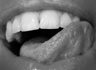 Diş bakımı, sağlıklı dişler ve gülümseme, ağzında beyaz dişler. Sağlıklı beyaz dişlerle gülümseme. Ağzını aç, dil dişlere değsin. Aşırı kapalı ağız, makro seksi dudak