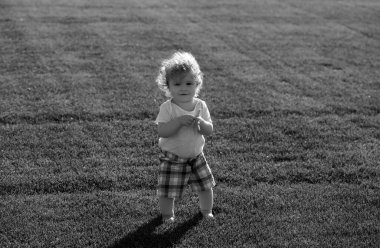 Güzel ilkbahar yeşil tarlasında bebek. Sağlıklı çocuk