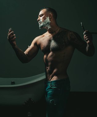 Kuaförler berber dükkanında yakışıklı bir adam için çalışıyorlar. Berber dükkanını ziyaret eden bir adam. Sakal kremi. Tıraş adam ve ustura adam. Berber berber dükkanında sakallı bir adamı tıraş ediyor.