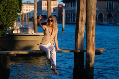 Güzel sarışın manken tatil için Venedik İtalya caddesinden ayrılıyor. Venedik 'e lüks bir seyahat. Sokaktaki en seksi kadın. Yaz tatilindeki kız Venedik 'teki ünlü turizm merkezini ziyaret ediyor.