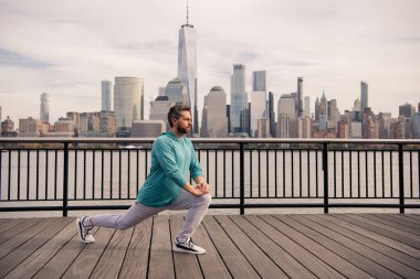 NYC 'de beden eğitimi son sınıf öğrencisi. Sağlıklı bir emeklilik hayatı. Aktif kıdemli adam dışarıda egzersiz yapıyor. Emeklilikten sonra aktif. Adam bacak çalıştırıyor kaslar hareket ediyor.