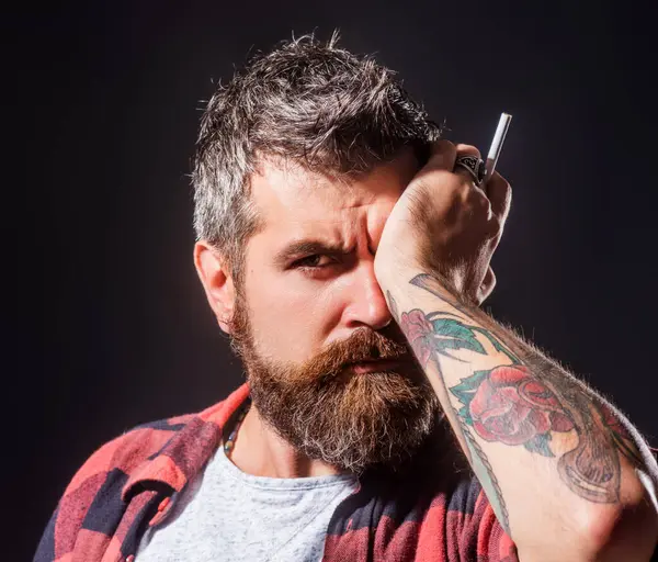 Beard man with cigarette. Beard care concept. The bristle irritated his skin. Shampoo and conditioner for a bearded man. Male beauty care, facial hair care. Bearded man smoke cigarette