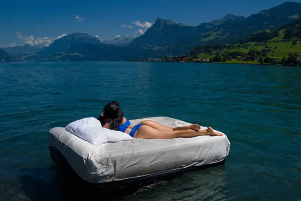 Comfort cozy bed concept. Woman with inflatable mattress in summer water. Sexy woman sleeping or resting on a mattress in the water. Water mattress concept. Sweet dreams. Summer rest