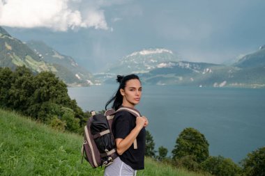 Gezgin kadın dağlarda gezer. Alpler yazı. Sırt çantasında yürüyüş yapan bir kadın. Yaşam tarzı macera konsepti orman ve göl vahşi doğada. Sırt çantalı özgürlük yolcusu kadın doğanın tadını çıkarıyor.