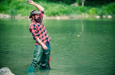 Fisherman man on river or lake with fishing rod