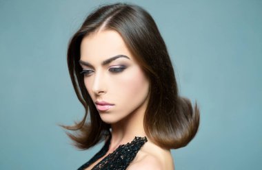 Güzellik kadını yüz. Kız Studio gri arka plan üzerinde. Yakın çekim portre. Saç şekillendirme. Moda, güzellik, kozmetik. Makyaj, pürüzsüz bir cilt. Dergisi sanat tasarım reklam, makyaj