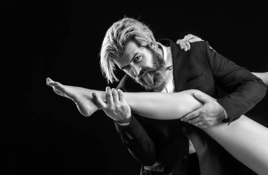 Takım elbiseli yakışıklı adam kadın bacakları yalıyor. Ayak fetişi olan lüks bir işadamı.