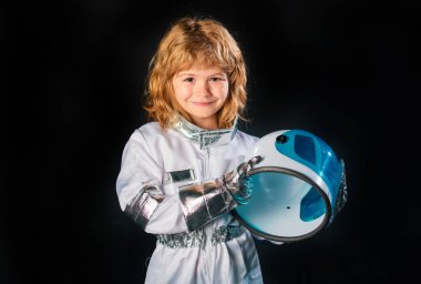 Çocuk astronot uzay kostümü giymiş, siyah giyinmiş.