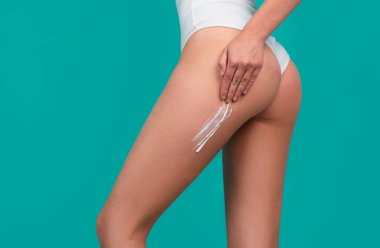 Body care. Woman applying cream on legs and buttocks. Female applying cosmetic cream from cellulite. Applying moisturizer cream on butt. Cellulite or anti cellulite treatment