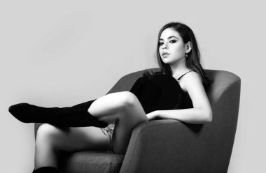 Moda modeli. Stüdyo arka planında güzel bir elbise giymiş güzel genç bir kadın. Moda mankeni, stüdyoda poz veren zarif bir kadın.