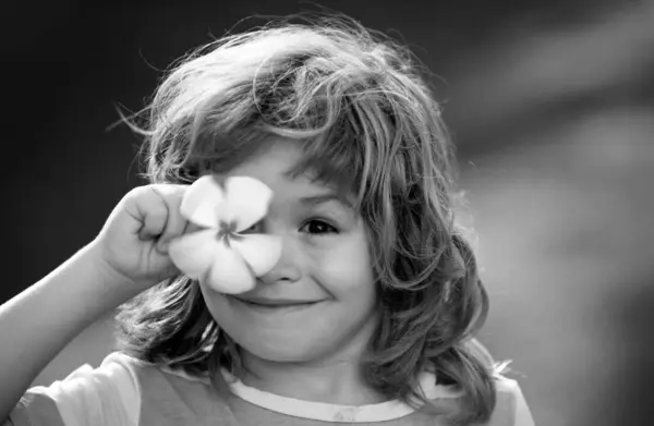 Porträtt Ett Lyckligt Skrattande Barn Med Ögon Plumeria Blomma Närbild — Stockfoto