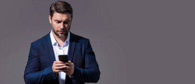 Stüdyonun arka planında izole edilmiş cep telefonu kullanan adam. Takım elbiseli adam aramalar için akıllı telefon kullanıyor, sosyal medya, mobil uygulama. Telefonda konuşan adam. Başlık için pankart, kopyalama alanı
