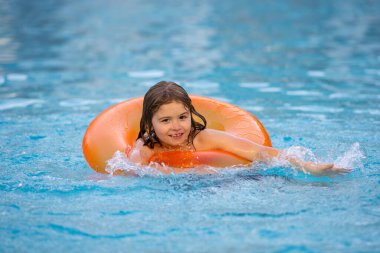 Yüzme havuzunda şişme yüzüğü olan çocuk. Yaz tatili. Yaz tatili. Yaz çocukları hafta sonu. Yüzme havuzunda bir çocuk. Aquapark 'ta şişme yüzük takan komik çocuk.