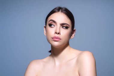 Gri arka planda durmuş soru soran bir kadın. Düşünceli bir ifade. Düşünceli bir yüz. Şüpheli bir kavram. Kafa karıştırıcı bir fikir hakkında düşünceli bir soru.