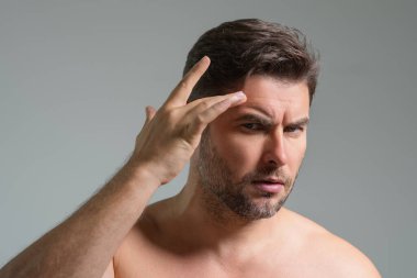 Yüz kremi süren güzel bir adamın güzel yüz portresi. İnsan için nemlendirici cilt kremi. Maske, deri değiştirme ve yaşlanmayı önleyici etki. Güzel erkek yüzü konsepti. Cilt bakımı ve yaşlanma. Yüz Kozmetiği