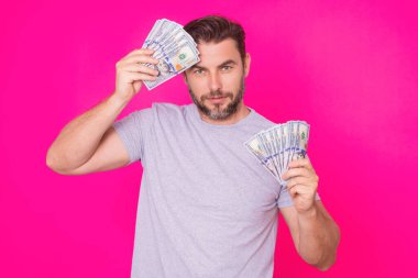 Çekici bir iş adamı para sayıyor. 100 dolarlık banknotlar tutan yakışıklı orta yaşlı bir adam. Parası olan başarılı bir iş adamı. Kâr ve finansal başarı. Dolar nakiti olan zengin bir adam.