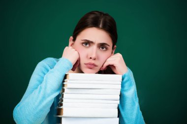 Üzgün bir üniversite öğrencisi. Yorgun liseli kız. Yorgun öğrenci çok fazla içiyor. Zor öğrenme. Üniversite öğrencisi endişeli. Kitapları istiflenmiş genç bayan öğrenci. Eğitim konsepti. Üniversitede ders ve ödev