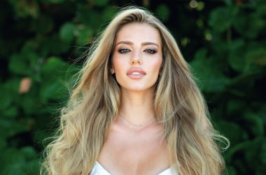 Güzel genç kız bahar parkında dinleniyor. Güzel bir kadının yakın portresi. Yaz parkında güzel bir genç kız. Yaz arkaplanındaki güzel kız modeli.