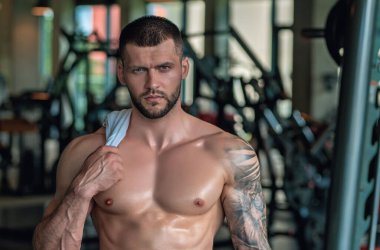 Spor salonunda egzersiz yapan güçlü bir genç adam. Spor kulübünde spor erkek antrenmanı. Genç adamın fitness antrenmanı var. Erkek sporcu egzersiz, spor ve antrenman yapar. İnsanlar spor ve sağlıklı yaşam tarzları