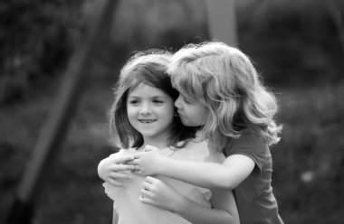 Küçük oğlan utangaç kızı kucaklıyor, küçük oğlan depresyondaki küçük kızı kucaklıyor, ilişki, arkadaşlık konsepti. Çocukları kucaklamak. Güzel çocuklar. İlk aşk