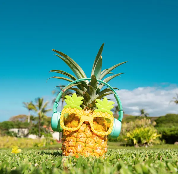 Yaz tropik ananas arka planı. Ananas güneş gözlüklü, mavi gökyüzü arka planında bir palmiye ağacının altında. Plajda kokteyl partisi, dinlenme, rahatlama ve yaz konsepti.