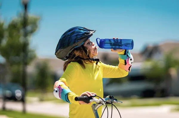 Kid riding bike in a helmet. Child riding bike in protective helmet. Safety kids sports and activity. Happy kid boy riding bike in summer park. Bike helmet, bicycle safety, cycling accessories