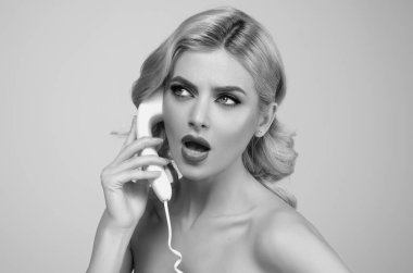 Sarışın kadın retro telefondan konuşuyor. Retro sabit hat telefonu. Sabit telefondan konuşan güzel, şehvetli genç bir kadın. Retro telefondan konuşan seksi kız. Kadın telefonu tut.