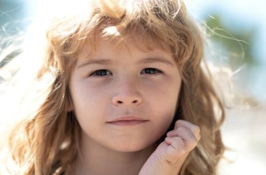 Çocuk portresi doğada, parkta ya da dışarıda. Yazlık parkta oynayan mutlu çocuğun yüzünü kapat.