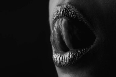 Dil yalayan dudaklar. Şehvetli bir ağız. Altın rujdaki öpücüğün sembolü. Cazibeli altın ağızlı. Dudaklarında altın boya var. Altın dudaklar, şehvetli kadın ağzı. Metalik gövde. Altın kavram