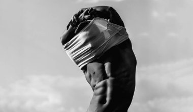 Seksi model vücut, çıplak gövde. Güçlü bir adam, baştan çıkarıcı bir eşcinsel. Kaslı, üstsüz, çekici bir adam. Üstsüz model. Stüdyoda çıplak eşcinsel pozu. Adam seksi görünüyor. Atletik kaslar