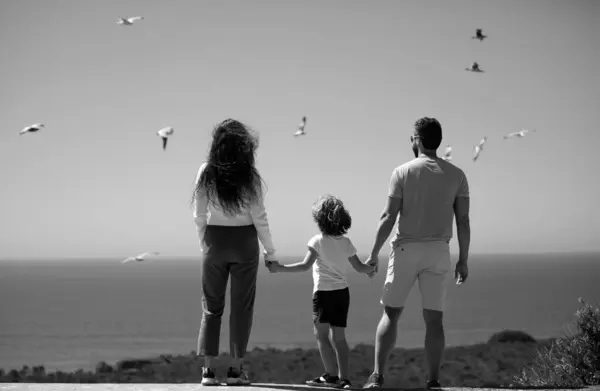 Summer holidays family. Father mother and child on the summer Florida beach at the sunset time. Concept of friendly family