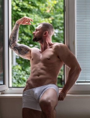 Handsome muscular man showing sexy body. Young sexy man portrait. Sexy guy with athletic flexing muscles. Sexy young handsome naked man. Seductive gay