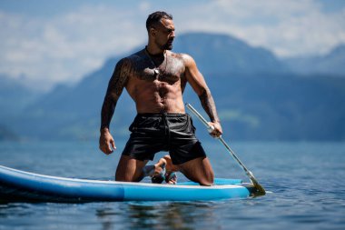 Sudaki seksi adam. Seksi manken. Doğada baştan çıkarıcı bir adam. Yakışıklı, üstsüz bir adam. Kaslı erkek vücudu fit. Kas modeli, sporcu genç adam. Kaslı erkek gövdesi, çıplak omuzlar.