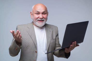 Profesör. Yaşlı bir adamın dizüstü bilgisayarı var. 60 'ların iş adamı Gri Stüdyo' nun arka planında izole edilmiş bir laptop kullanıyor. Laptop bilgisayarına bağlanmış yetişkin bir adam. Dizüstü bilgisayarda çalışan kıdemli adam.