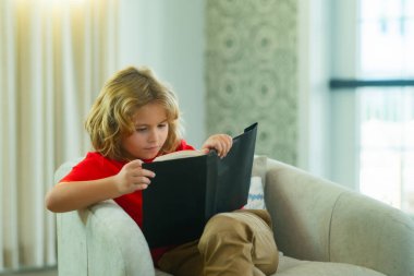 Kid read book at home. Concept of education, childhood, book reading and inspiration