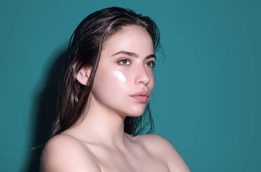 Kozmetik krem süren bir kadın. Yüzüne cilt bakımı yapan spa modeli. Sabah makyajı. Cilt kaldırma ve yaşlanma önleyici etki için nemlendirici cilt kremi, losyon veya maske