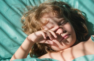 Çocuklar uyuyor, çocuk parlak bir yatak odasında uyurken yatakta yatıyor.